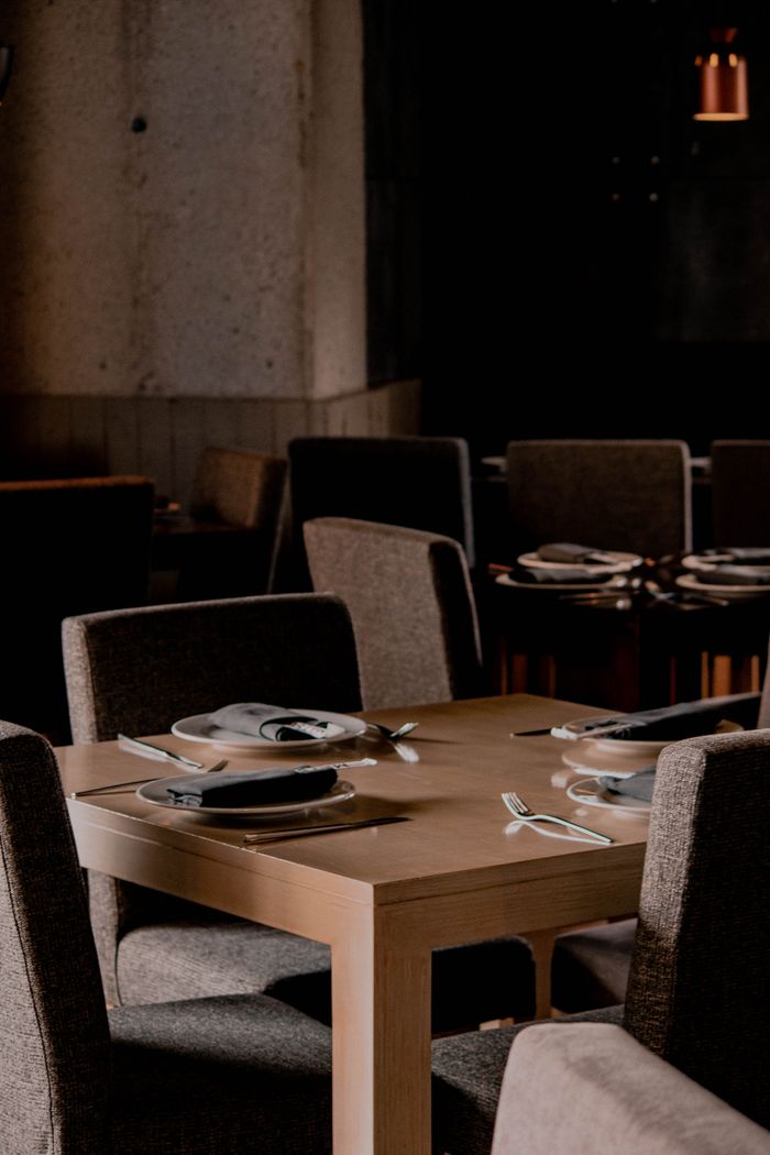 journey-02 Chic restaurant setting with modern decor, chairs, and a beautifully set table ready for dining.