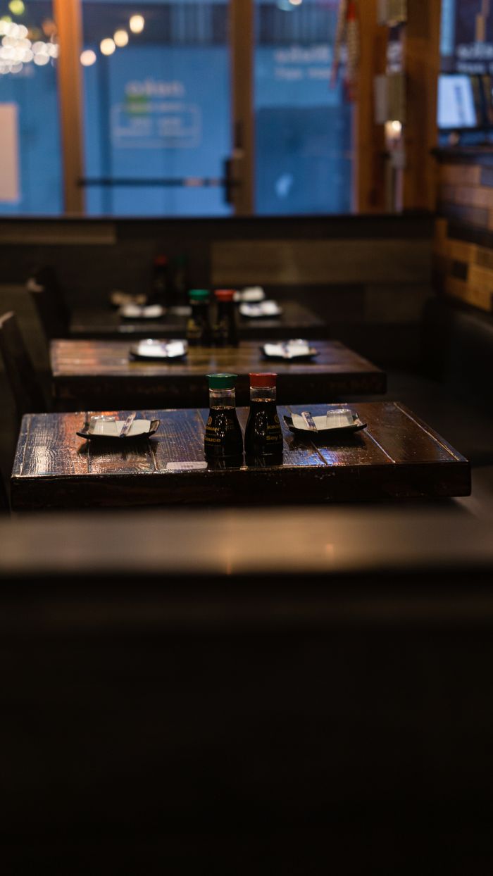 vision Warm and inviting restaurant interior featuring wooden tables set with condiments and plates.