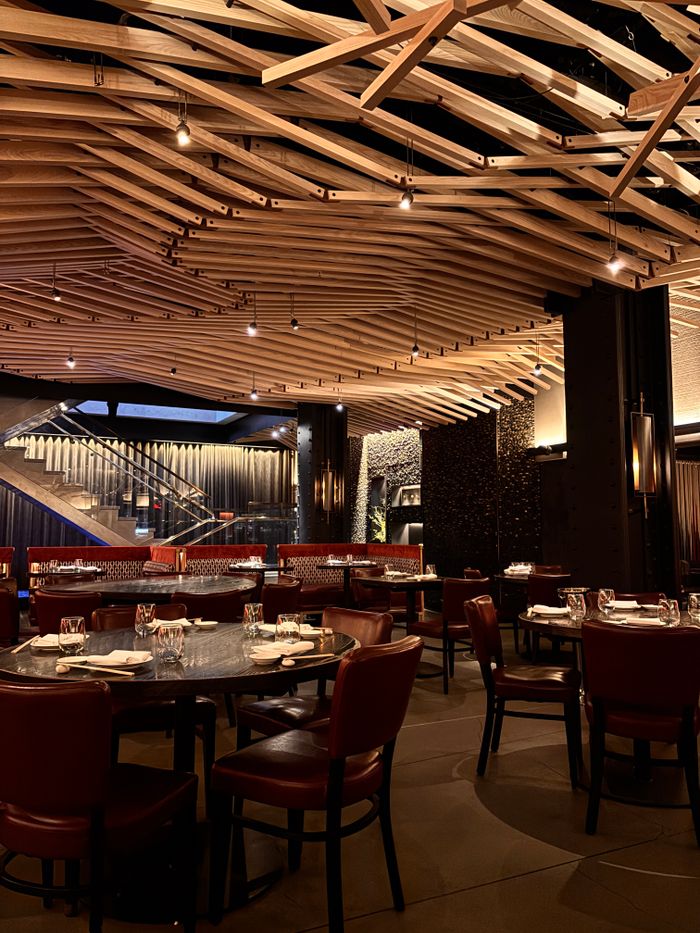 Elegant restaurant interior featuring wooden ceiling and red leather seating.