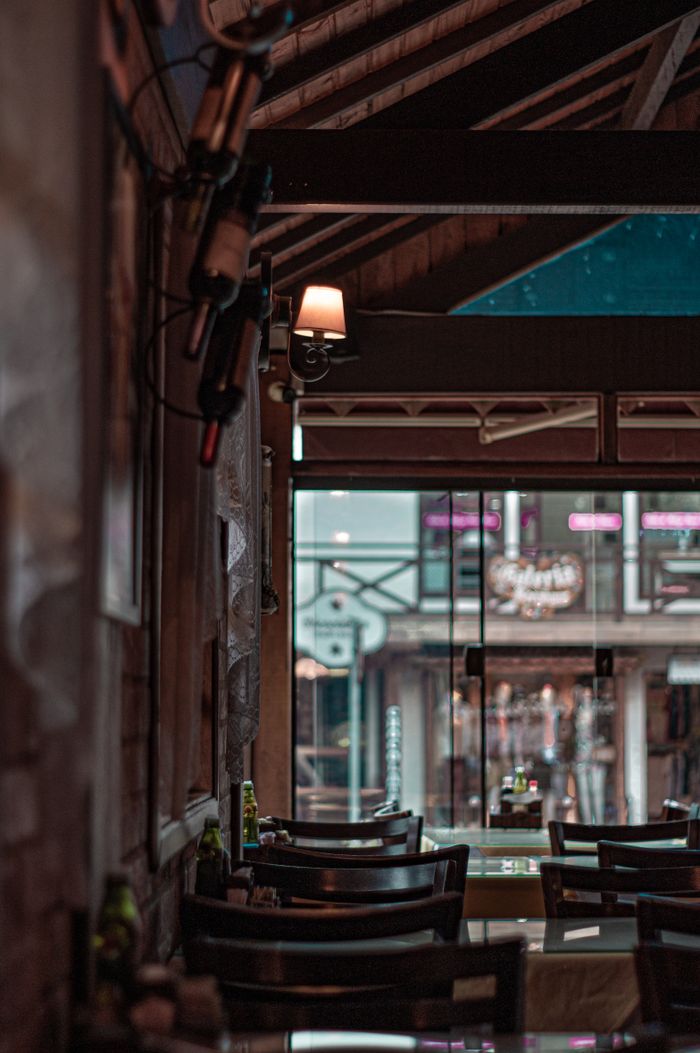 Warm, inviting restaurant interior with rustic charm and wine bottles on display.