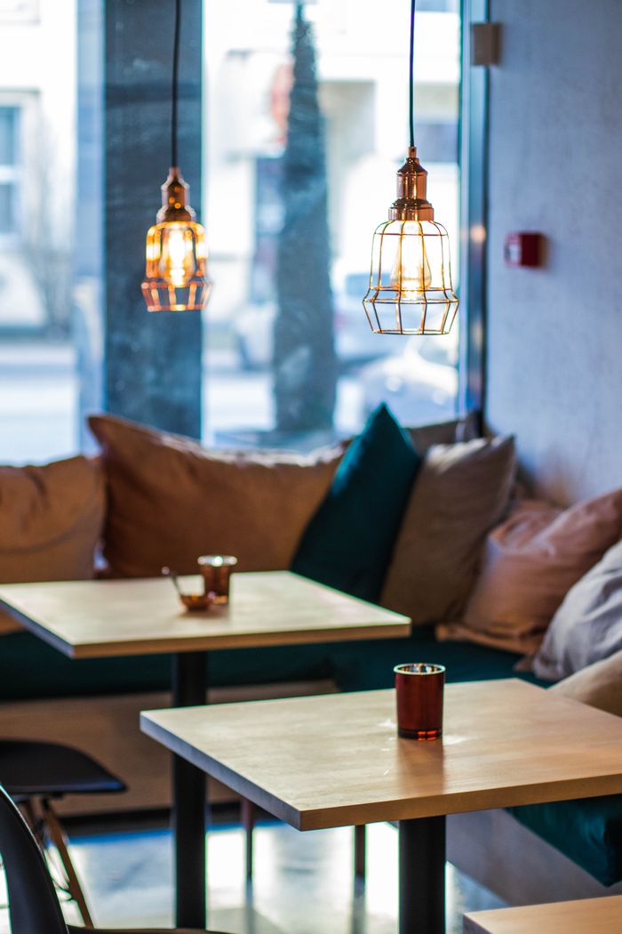 journey-01 Warm and inviting cafe interior featuring modern pendant lighting and comfortable seating.
